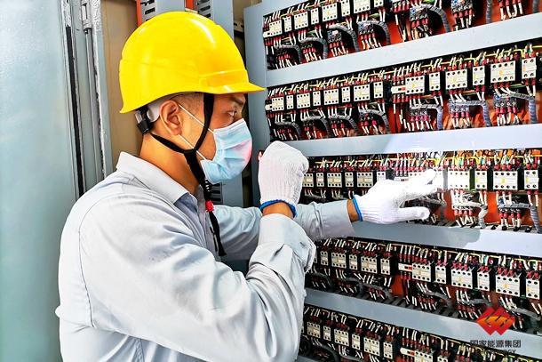 图为设备点检员正在检查电气柜接线情况