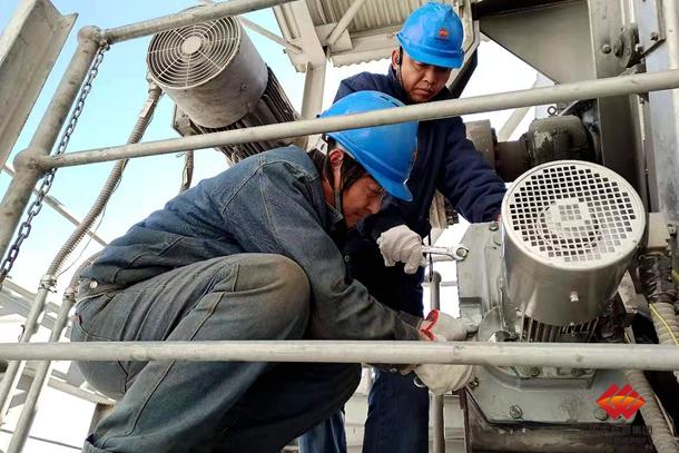 图为检修人员正在紧固电机螺栓